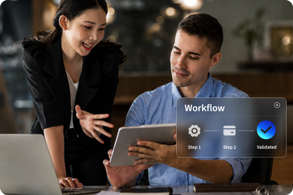 a woman and a woman work at computers with a depiction of a multi-step workflow below them